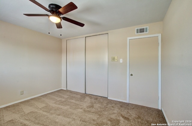 unfurnished bedroom with light carpet, a closet, and ceiling fan