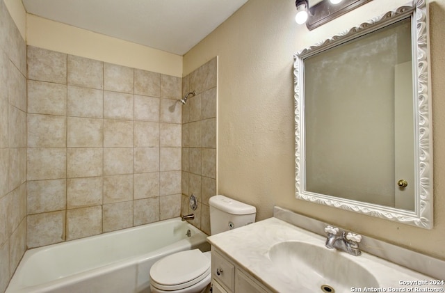 full bathroom with toilet, vanity, and tiled shower / bath