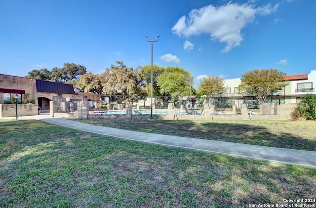 view of community featuring a swimming pool and a yard