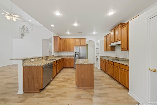 kitchen featuring kitchen peninsula, light hardwood / wood-style flooring, a kitchen island, and stainless steel appliances