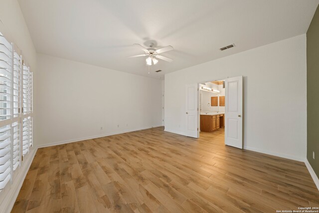 unfurnished bedroom featuring connected bathroom, ceiling fan, and light hardwood / wood-style floors