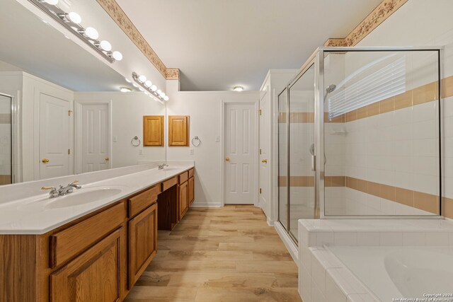 bathroom featuring vanity, independent shower and bath, and wood-type flooring