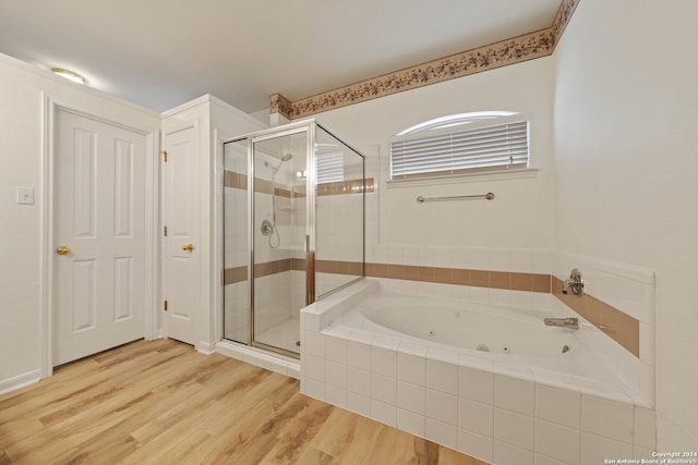 bathroom featuring wood-type flooring and plus walk in shower