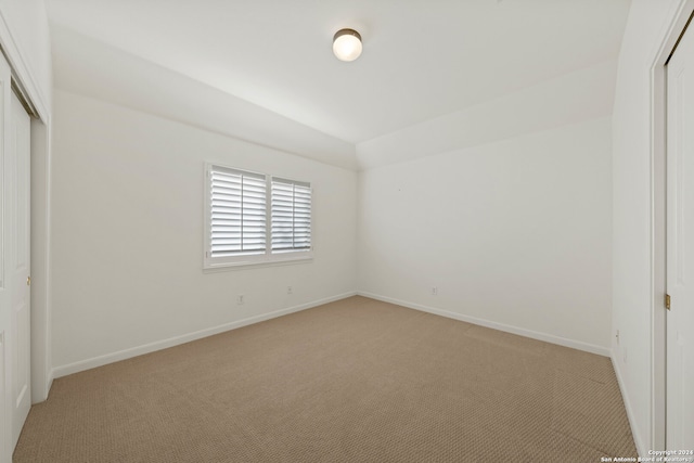 unfurnished bedroom with light carpet and a closet