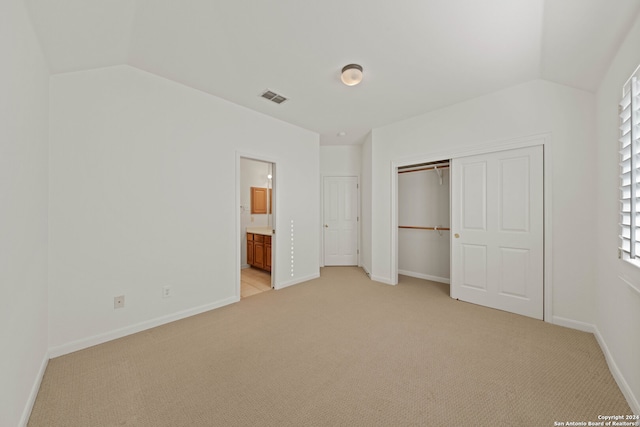 unfurnished bedroom with light carpet, vaulted ceiling, and multiple windows