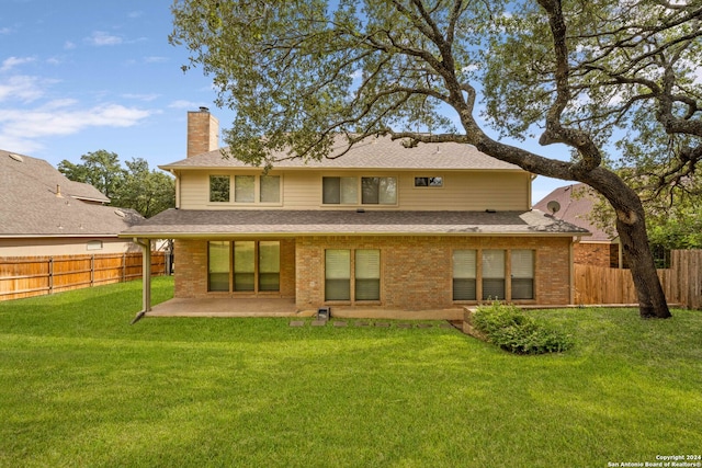 back of property with a lawn and a patio