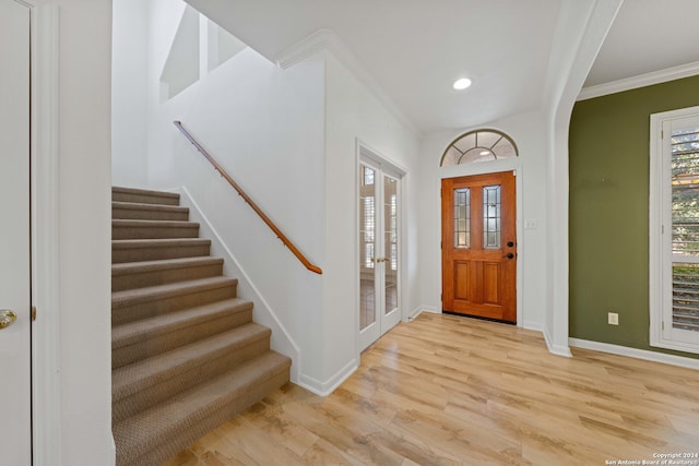 entryway with crown molding and light wood-type flooring