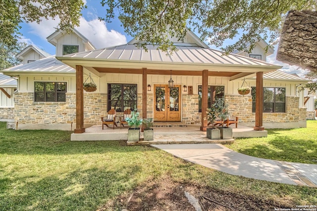 rear view of house featuring a lawn, french doors, and a porch