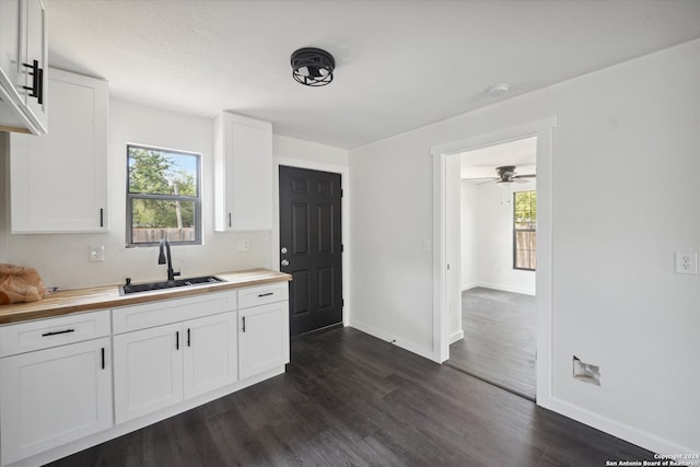 kitchen featuring white cabinets, sink, wooden counters, dark wood-type flooring, and ceiling fan