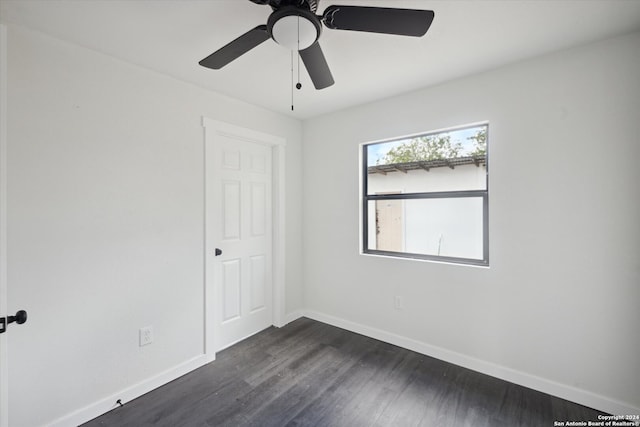 unfurnished room featuring ceiling fan and dark wood-type flooring