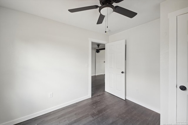 unfurnished bedroom with ceiling fan and dark wood-type flooring