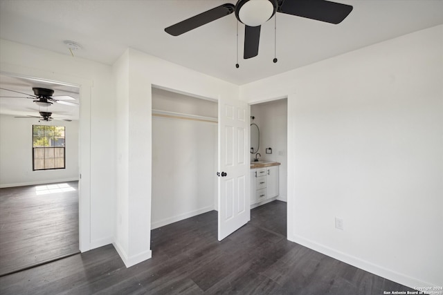 unfurnished bedroom featuring a closet, ceiling fan, dark wood-type flooring, and sink