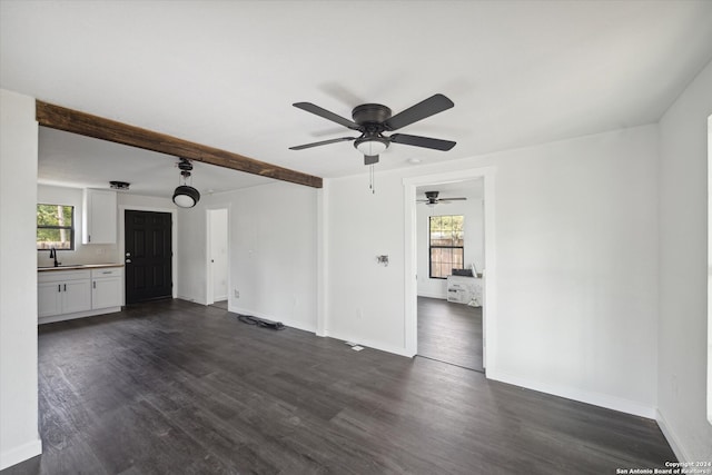 unfurnished living room featuring ceiling fan, dark wood-type flooring, and sink