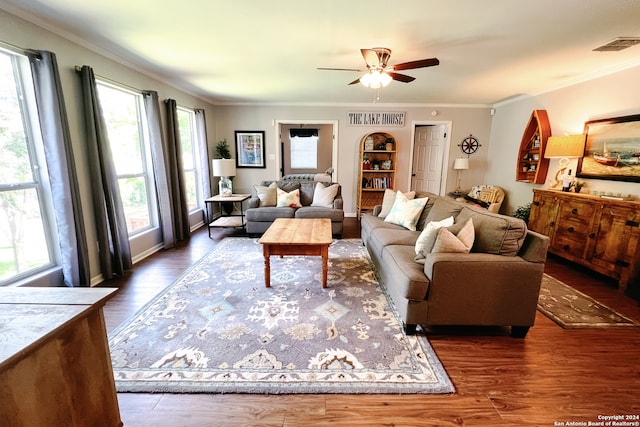 living room with ornamental molding, ceiling fan, and dark wood-type flooring