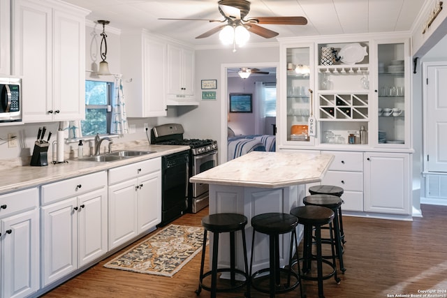 kitchen with white cabinets, hanging light fixtures, sink, and a kitchen island