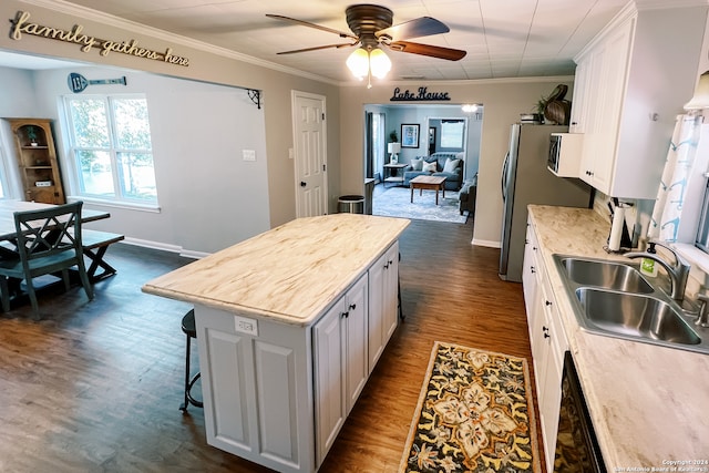 kitchen with sink, white cabinets, dark wood-type flooring, and a kitchen island