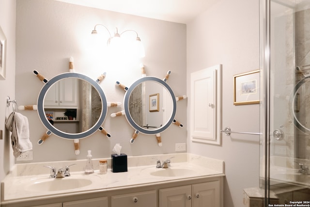 bathroom featuring a shower with door and vanity