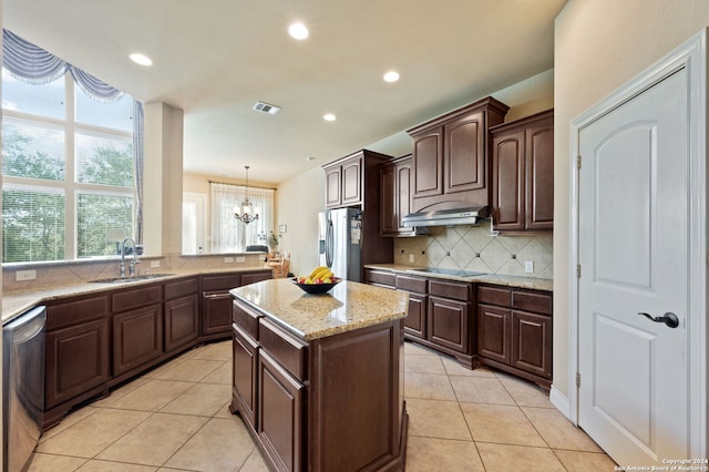 kitchen with dark brown cabinetry, sink, a center island, stainless steel appliances, and hanging light fixtures