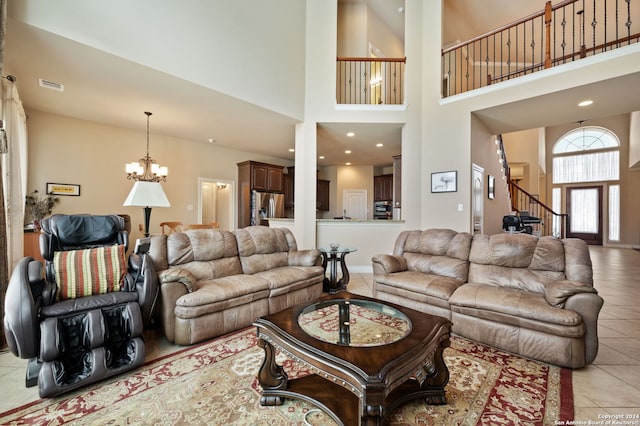 living room featuring a towering ceiling, light tile patterned flooring, and an inviting chandelier