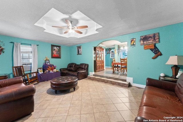 22620 Little Walnut Dr, San Antonio, TX 78264 - living area featuring arched walkways, a ceiling fan, a raised ceiling, light tile patterned floors, and a textured ceiling