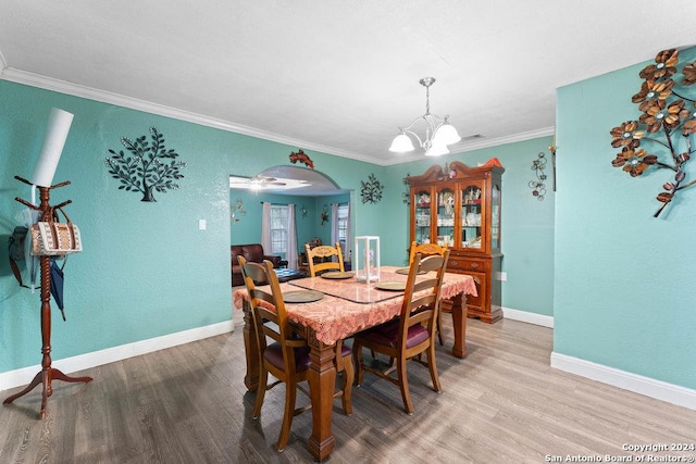 22620 Little Walnut Dr, San Antonio, TX 78264 - dining area featuring a chandelier, wood finished floors, ornamental molding, baseboards, and arched walkways