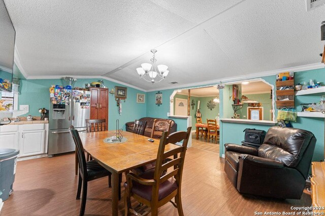 22620 Little Walnut Dr, San Antonio, TX 78264 - dining area featuring a chandelier, ornamental molding, light wood finished floors, a textured ceiling, and lofted ceiling