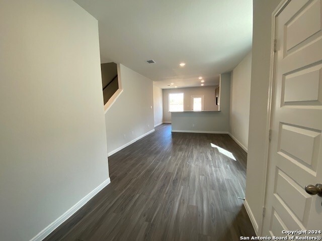 unfurnished living room with dark wood-type flooring