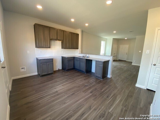 kitchen featuring kitchen peninsula, dark hardwood / wood-style floors, and sink