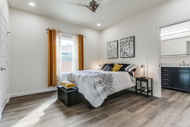 bedroom with wood-type flooring, ceiling fan, and sink