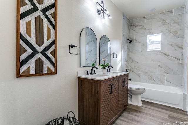 full bathroom featuring vanity, tiled shower / bath combo, hardwood / wood-style flooring, and toilet