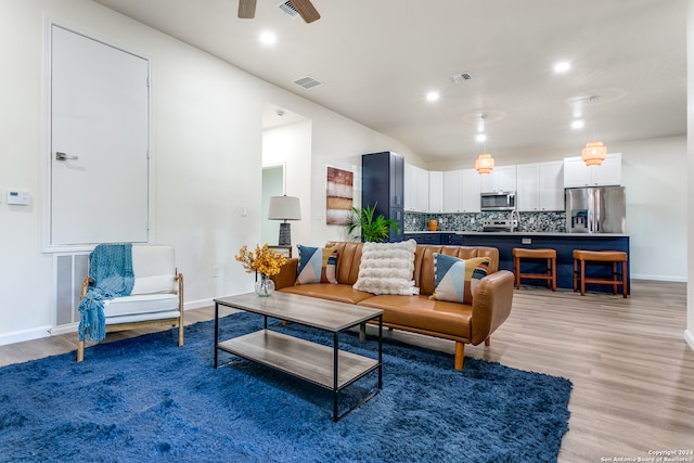 living room with ceiling fan and light hardwood / wood-style floors