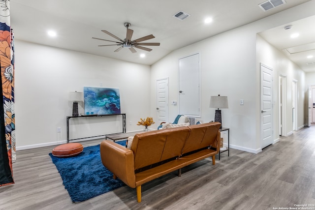 living room with wood-type flooring, ceiling fan, and lofted ceiling