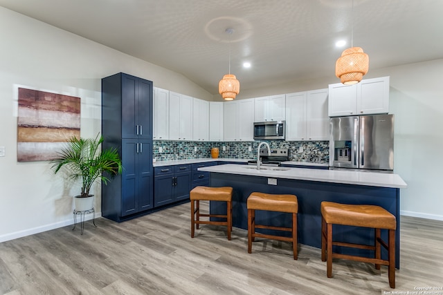 kitchen featuring a breakfast bar, sink, appliances with stainless steel finishes, and pendant lighting