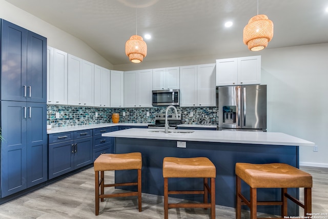 kitchen featuring sink, hanging light fixtures, blue cabinetry, light wood-type flooring, and stainless steel appliances