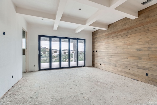 spare room with beamed ceiling, wooden walls, and coffered ceiling