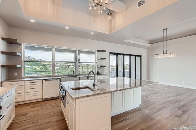 23202 Walker Rdg, San Antonio, TX 78255 - kitchen with open shelves, a sink, a chandelier, light wood-style floors, and recessed lighting