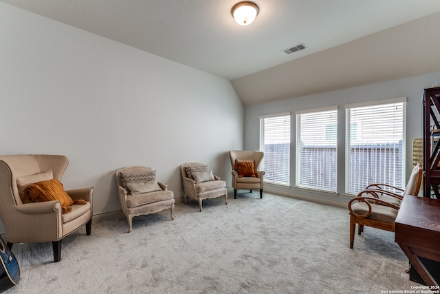 sitting room featuring vaulted ceiling, a water view, and light colored carpet