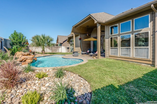 view of swimming pool featuring ceiling fan, a patio area, and a lawn