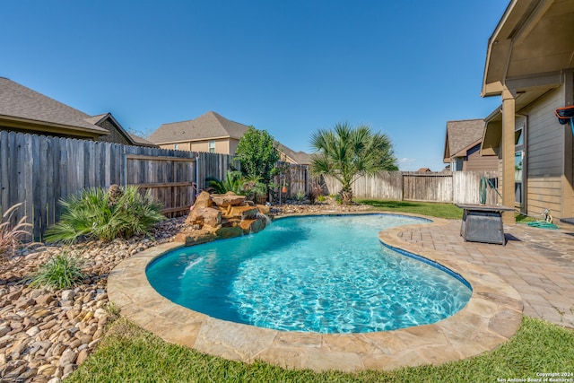 view of swimming pool featuring pool water feature and a patio