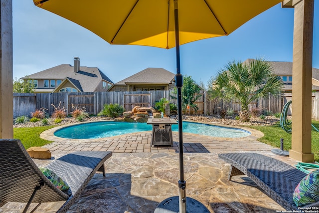 view of swimming pool with pool water feature and a patio