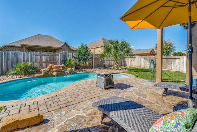 view of swimming pool with pool water feature and a patio