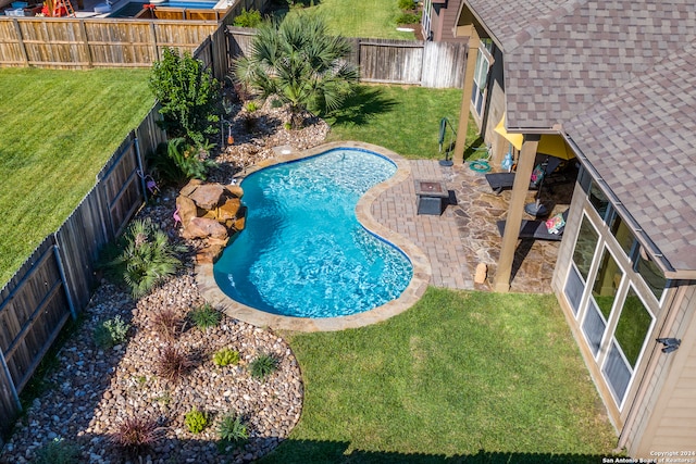 view of swimming pool featuring a yard and a patio