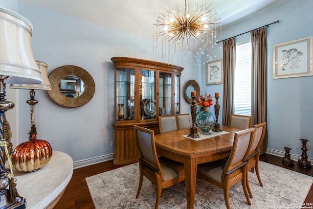 dining space featuring dark hardwood / wood-style flooring and an inviting chandelier