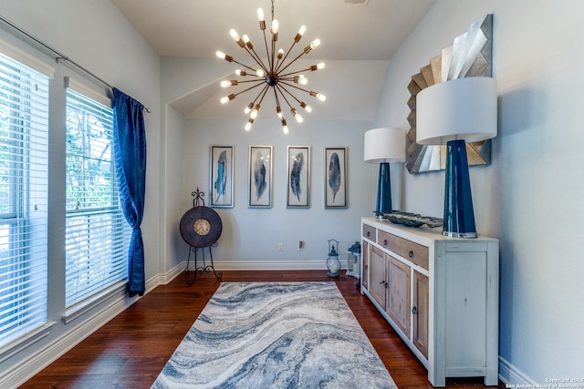 living area featuring dark hardwood / wood-style flooring, vaulted ceiling, and a notable chandelier