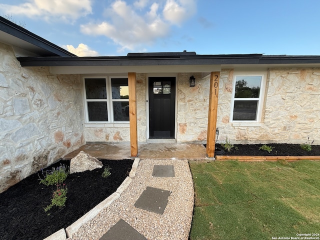 doorway to property with a yard