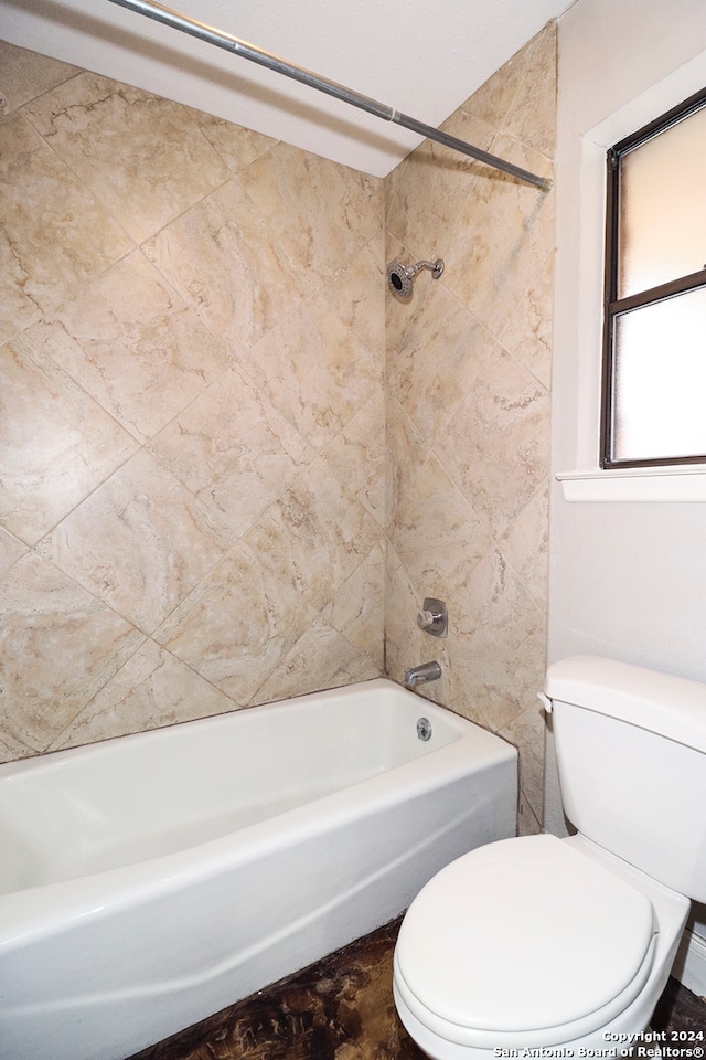 bathroom with tiled shower / bath and toilet