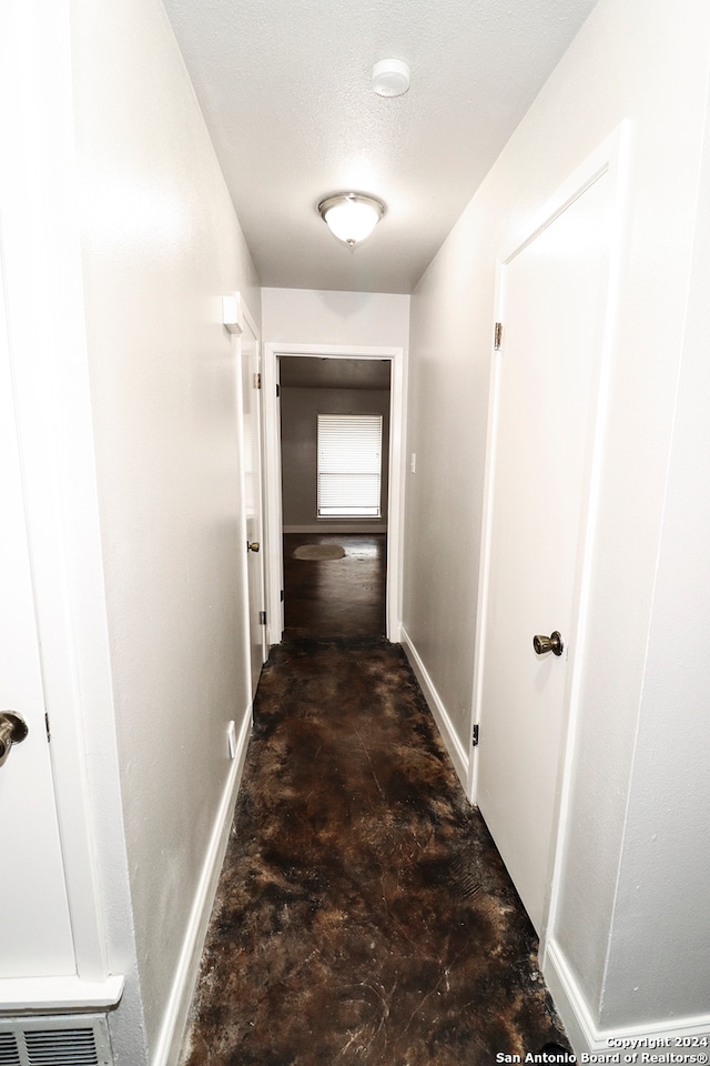 hall featuring a textured ceiling