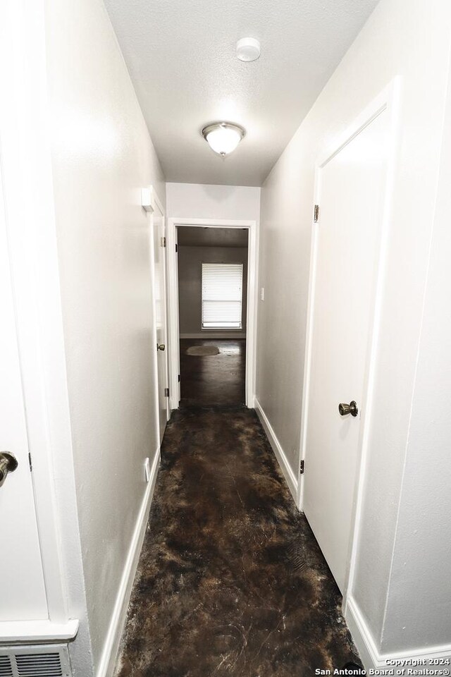 7227 Trace Buckle, San Antonio, TX 78240 - hallway with baseboards and concrete floors