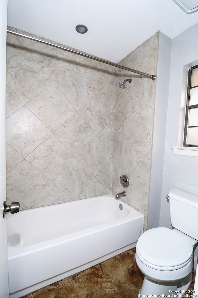 bathroom featuring toilet and tiled shower / bath