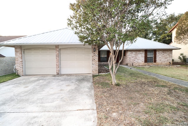 ranch-style house featuring a front lawn and a garage